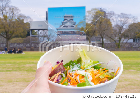 Enjoying a solo spring picnic lunch with Kumamoto Castle (currently under repair) as the backdrop. Enjoying a solo spring picnic lunch with Kumamoto Castle (currently under repair) as the backdrop. 138445123