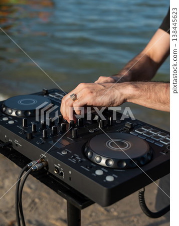 Close up of DJ's hands while working outdoors. Close up of DJ's hands while working outdoors. 138445623