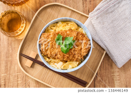 Katsudon: Pork cutlet served over egg, garnished with mitsuba (Japanese parsley). Katsudon: Pork cutlet served over egg, garnished with mitsuba (Japanese parsley). 138446149