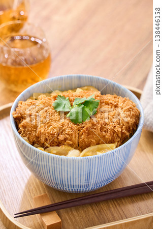 Katsudon: Pork cutlet served over egg, garnished with mitsuba (Japanese parsley). Katsudon: Pork cutlet served over egg, garnished with mitsuba (Japanese parsley). 138446158