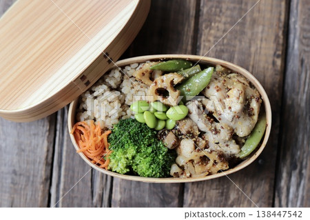 一份健康便當,裝在傳統的便當盒裡,裡面有芥末雞肉和大量蔬菜,熱量低於500卡路里。 一份健康便當,裝在傳統的便當盒裡,裡面有芥末雞肉和大量蔬菜,熱量低於500卡路里。 138447542