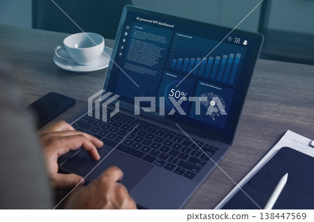 Hands operating laptop with AI powered analytics dashboard featuring charts, graphs, and performance indicators in office setting, representing data monitoring, business intelligence, and 138447569