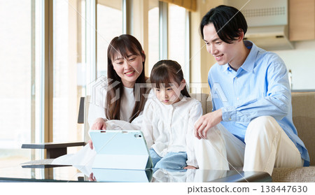 Family looking at a tablet: parent and child, husband and wife, girl Family looking at a tablet: parent and child, husband and wife, girl 138447630