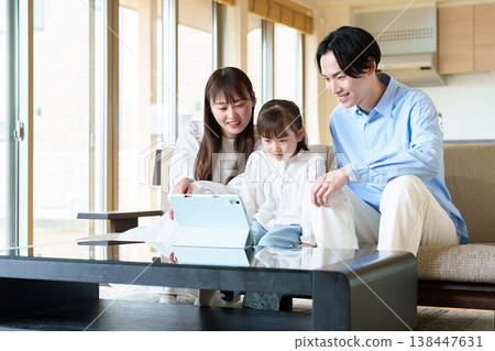 Family looking at a tablet: parent and child, husband and wife, girl Family looking at a tablet: parent and child, husband and wife, girl 138447631