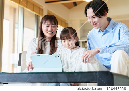 Family looking at a tablet: parent and child, husband and wife, girl Family looking at a tablet: parent and child, husband and wife, girl 138447638