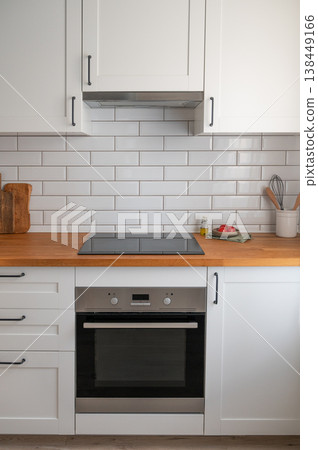 Modern kitchen wooden countertop with stove, oven and tiled wall background. Modern kitchen wooden countertop with stove, oven and tiled wall background. 138449166