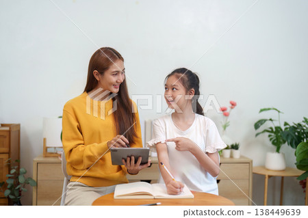 Mother and daughter using a tablet for learning Mother and daughter using a tablet for learning 138449639