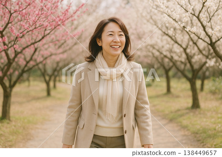 A woman walking along cherry blossoms 138449657