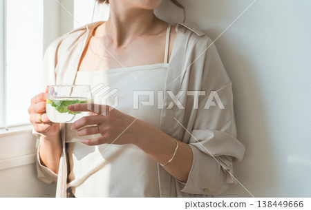Women who drink detox water, lemon water, and mint water. Women who drink detox water, lemon water, and mint water. 138449666