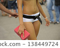 promo girl in white shorts holding a pink sponge, man hand trying to touch her, closeup 138449724