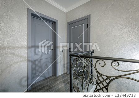 Modern Classic Hallway with Grey Doors and Wrought Iron Railings 138449738