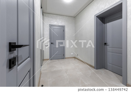 Modern Hallway Interior with Grey Doors and Stone Tile Floor 138449742
