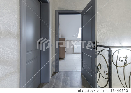 Modern Classic Hallway with Grey Doors and Wrought Iron Railings 138449750
