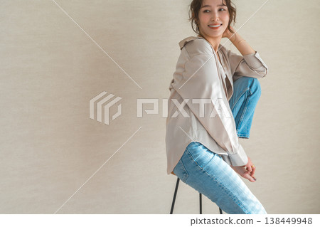 高腳椅，身穿牛仔服的女模特兒坐在椅子上 138449948