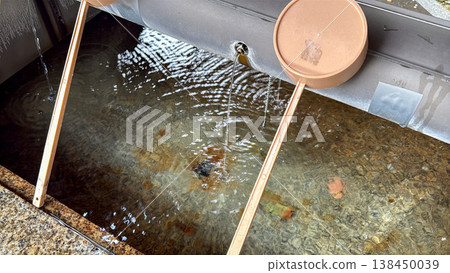 A scene of purification at a shrine's water basin, with a ladle and flowing water. A scene of purification at a shrine's water basin, with a ladle and flowing water. 138450039