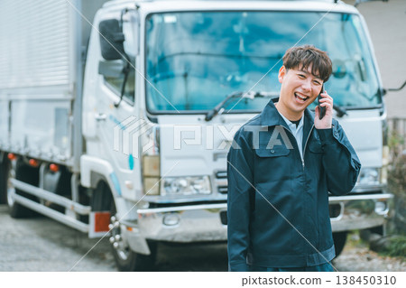 Truck driver making a phone call on his smartphone Truck driver making a phone call on his smartphone 138450310
