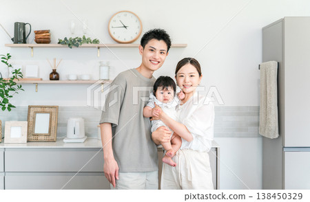 A couple and family holding their baby in the kitchen. A couple and family holding their baby in the kitchen. 138450329