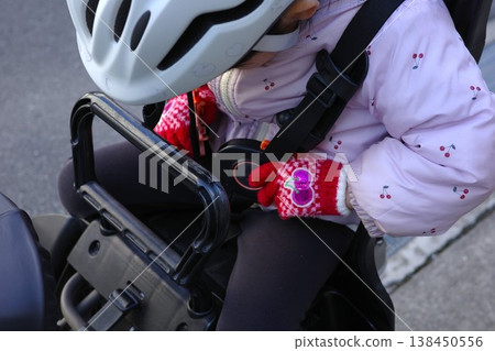 A child wearing a helmet while riding a bicycle A child wearing a helmet while riding a bicycle 138450556