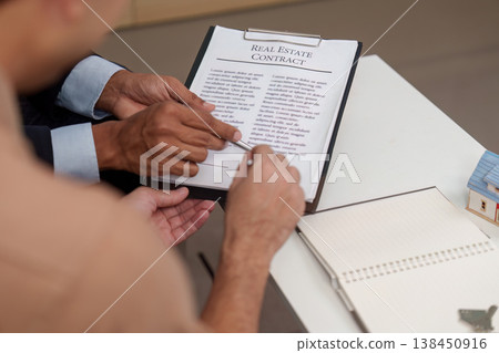 Real estate agent discussing contract details with client Real estate agent discussing contract details with client 138450916