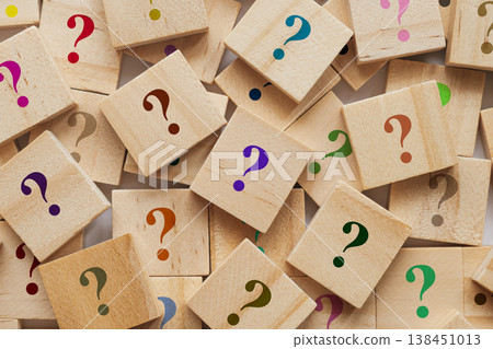 Too many wooden cubes with colorful question marks. Scattered blocks on blurred background symbolize curiosity and problem solving Too many wooden cubes with colorful question marks. Scattered blocks on blurred background symbolize curiosity and problem solving 138451013