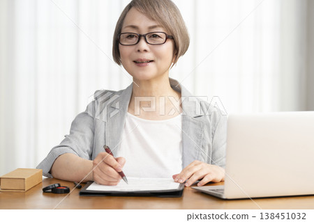 A senior woman signs and seals a contract. A senior woman signs and seals a contract. 138451032