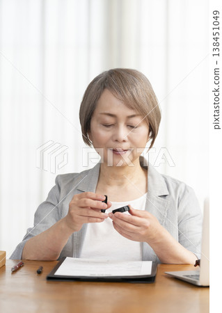 一位老年婦女簽署並蓋章了一份合約。 一位老年婦女簽署並蓋章了一份合約。 138451049