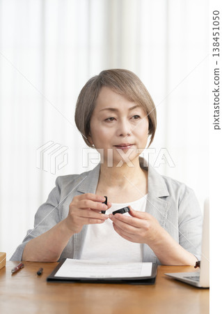 一位老年婦女簽署並蓋章了一份合約。 一位老年婦女簽署並蓋章了一份合約。 138451050