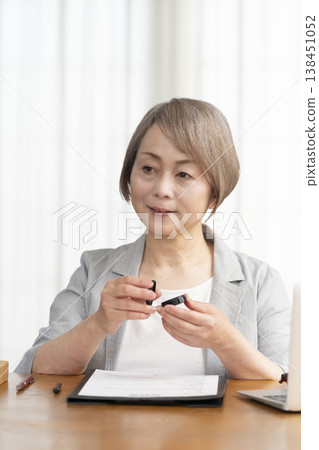 一位老年婦女簽署並蓋章了一份合約。 一位老年婦女簽署並蓋章了一份合約。 138451052