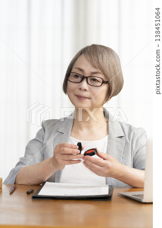 一位老年婦女簽署並蓋章了一份合約。 一位老年婦女簽署並蓋章了一份合約。 138451064