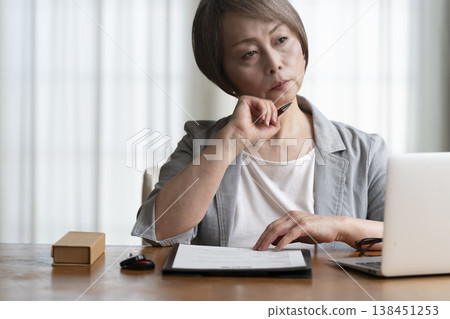 Senior woman hesitant to sign and seal contract - negative Senior woman hesitant to sign and seal contract - negative 138451253