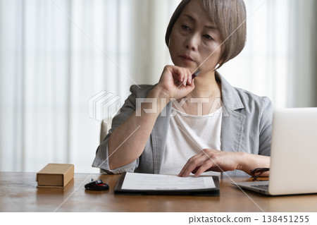 Senior woman hesitant to sign and seal contract - negative Senior woman hesitant to sign and seal contract - negative 138451255