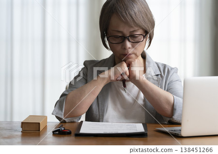Senior woman hesitant to sign and seal contract - negative 138451266