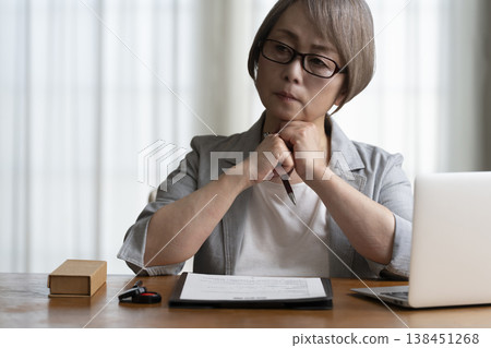 Senior woman hesitant to sign and seal contract - negative Senior woman hesitant to sign and seal contract - negative 138451268