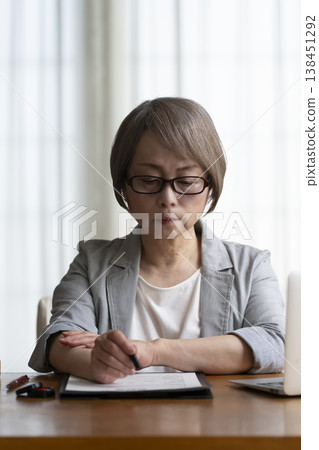Senior woman hesitant to sign and seal contract - negative Senior woman hesitant to sign and seal contract - negative 138451292