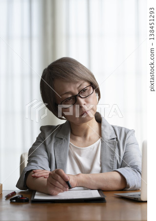 Senior woman hesitant to sign and seal contract - negative Senior woman hesitant to sign and seal contract - negative 138451293