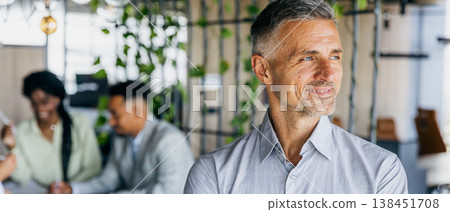 Highranking professional analyzing plans with attentive colleagues nearby 138451708
