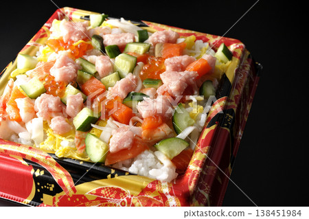 A photo of a generously topped chirashi sushi against a black background. A photo of a generously topped chirashi sushi against a black background. 138451984
