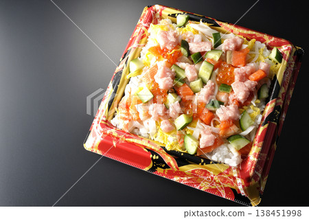 A photo of a generously topped chirashi sushi against a black background. A photo of a generously topped chirashi sushi against a black background. 138451998