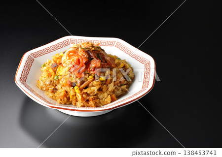 Spicy kimchi fried rice photographed alone against a black background. 138453741