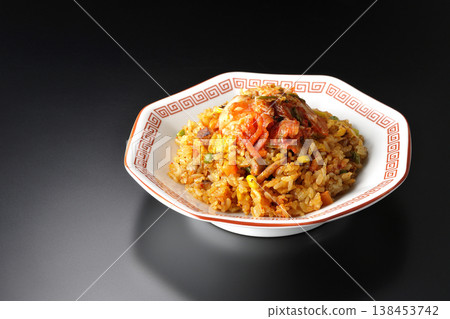 Spicy kimchi fried rice photographed alone against a black background. Spicy kimchi fried rice photographed alone against a black background. 138453742