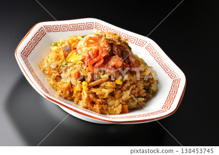 Spicy kimchi fried rice photographed alone against a black background. 138453745