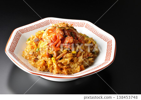 Spicy kimchi fried rice photographed alone against a black background. 138453748