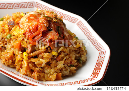 Spicy kimchi fried rice photographed alone against a black background. Spicy kimchi fried rice photographed alone against a black background. 138453754