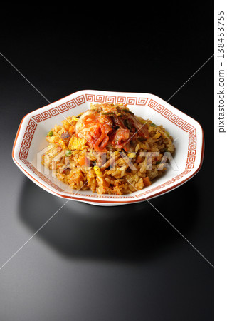 Spicy kimchi fried rice photographed alone against a black background. 138453755