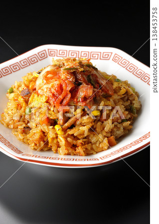 Spicy kimchi fried rice photographed alone against a black background. 138453758