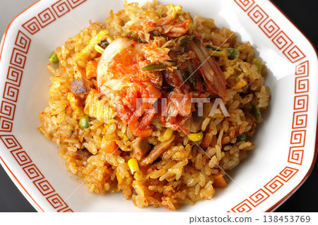 Spicy kimchi fried rice photographed alone against a black background. 138453769