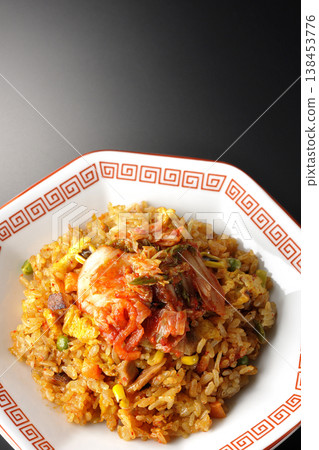 Spicy kimchi fried rice photographed alone against a black background. 138453776
