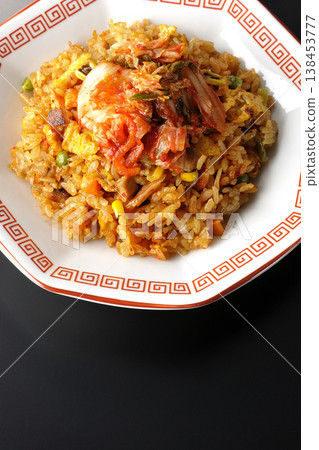 Spicy kimchi fried rice photographed alone against a black background. Spicy kimchi fried rice photographed alone against a black background. 138453777