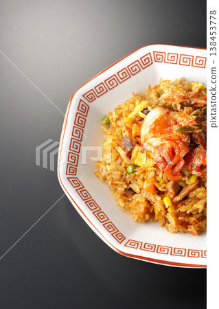 Spicy kimchi fried rice photographed alone against a black background. 138453778