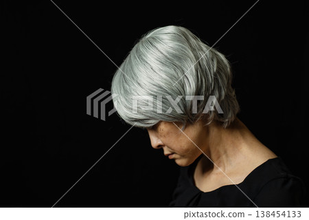 An image of a grandmother looking down sadly. 138454133